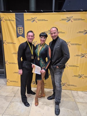 Marina und Alex freuen sich zusammen mit ihrem Trainer Sergiu Luca über ihren Erfolg